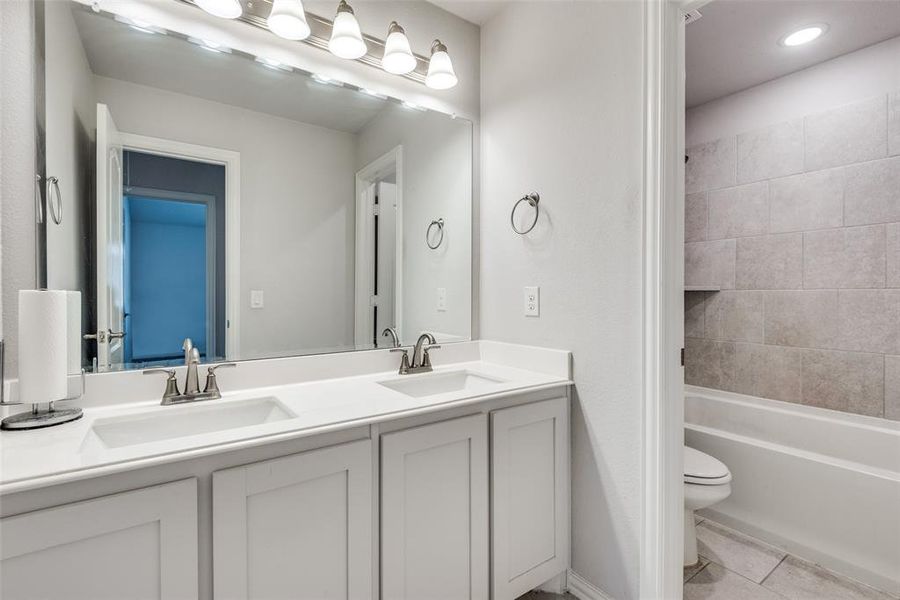 Bathroom with tile patterned flooring, vanity, and toilet