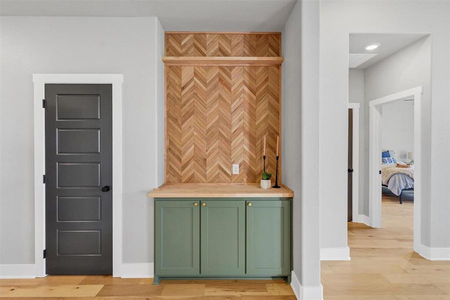 Bar area with green cabinets, light wood-style flooring, and wooden counters Bar area with green cabinets, light wood-style flooring, and wooden counters
