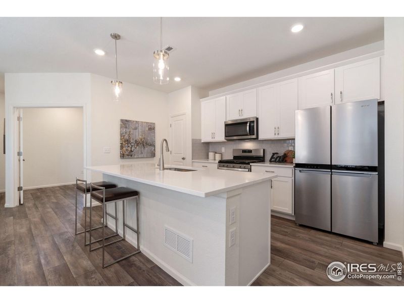 Large Kitchen Island With Quartz Counters Provides Extra Work Space. Note the Luxury Upgraded Wide Plank Vinyl Flooring Which Provides Easy Maintenance