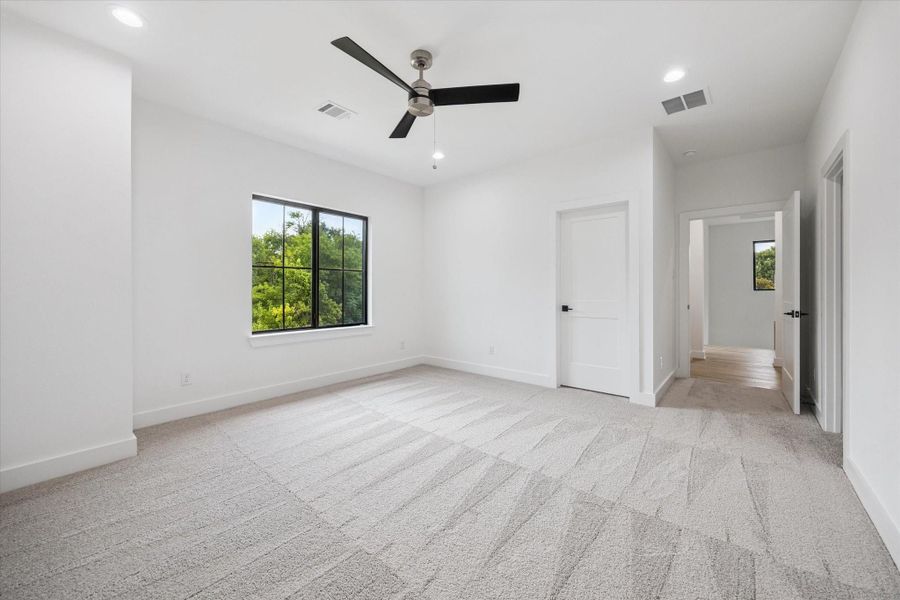 Generously sized secondary bedroom offering extra privacy and treetop views. Soft neutral carpet, sleek black ceiling fan, and access to its own ensuite bath make it a comfortable guest or family retreat. Generously sized secondary bedroom offering extra privacy and treetop views. Soft neutral carpet, sleek black ceiling fan, and access to its own ensuite bath make it a comfortable guest or family retreat.