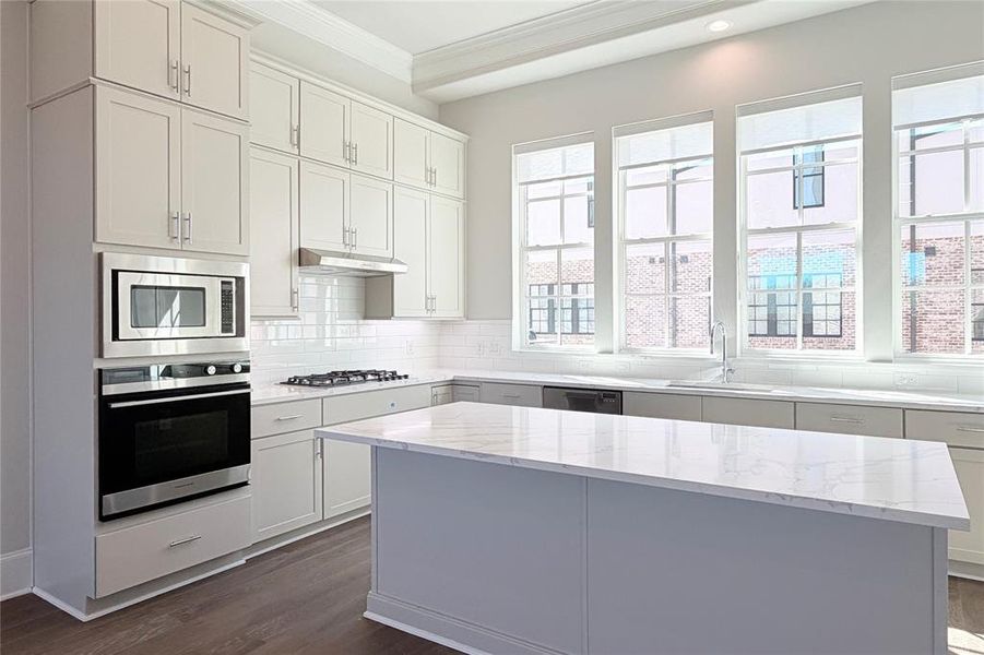 Progress photo of actual unit. Oversized kitchen island, pre-wired for pendant lighting, 5 piece appliance package.