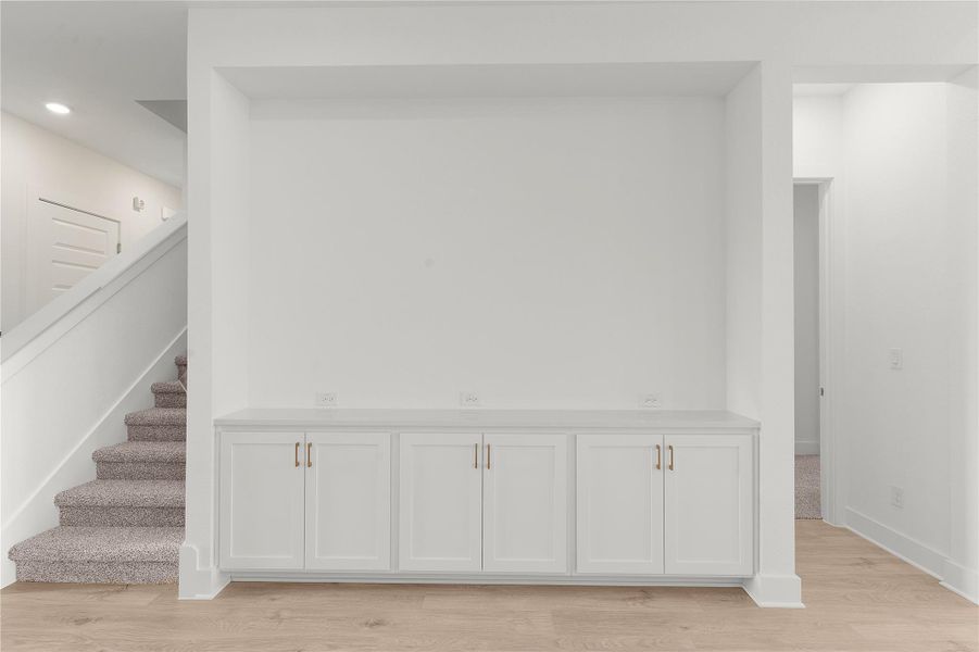 Stairway with wood finished floors and recessed lighting