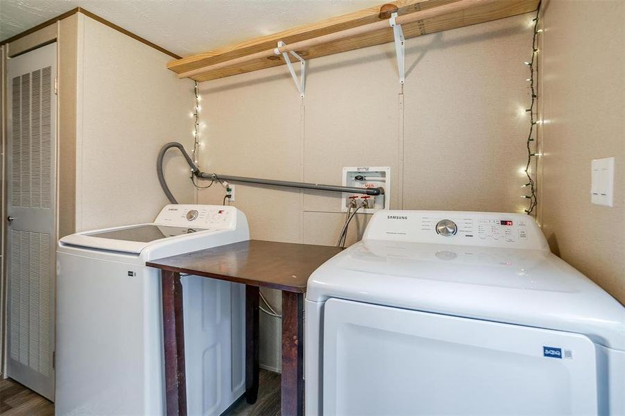 Washroom featuring dark wood-type flooring and independent washer and dryer