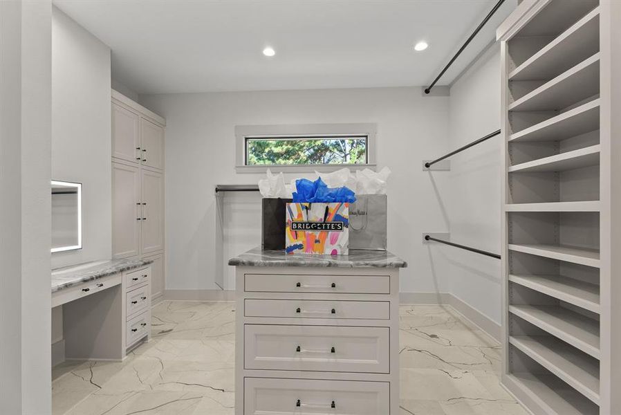 Walk in closet featuring light marble finish floors