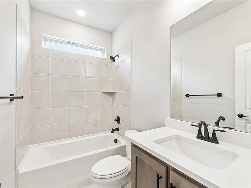Bathroom featuring toilet, vanity, and tub / shower combination