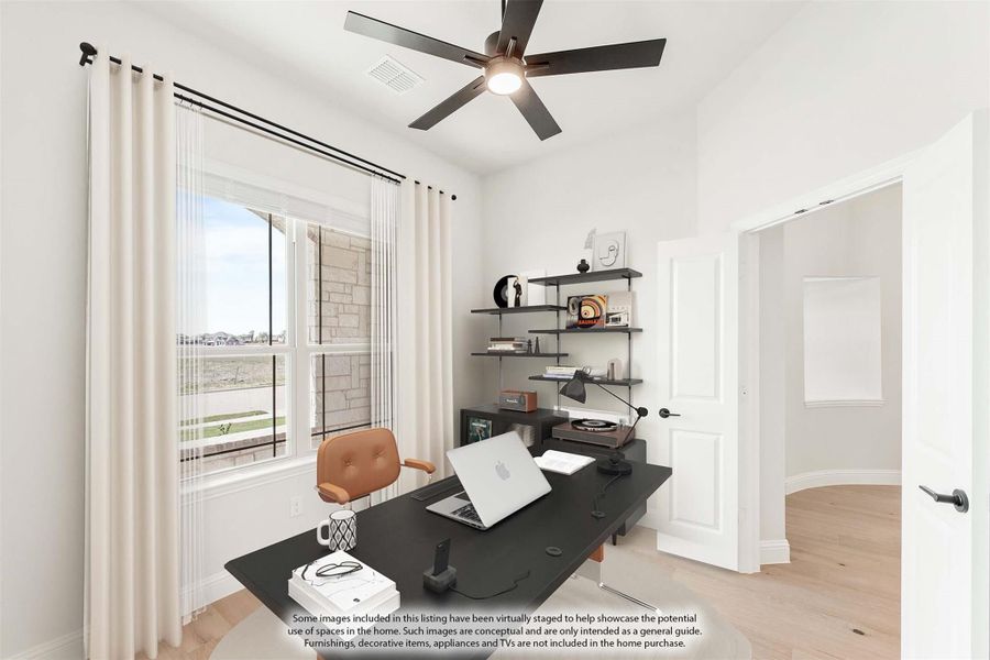 Home office with dark desk, wall shelves, ceiling fan, and large window with natural light