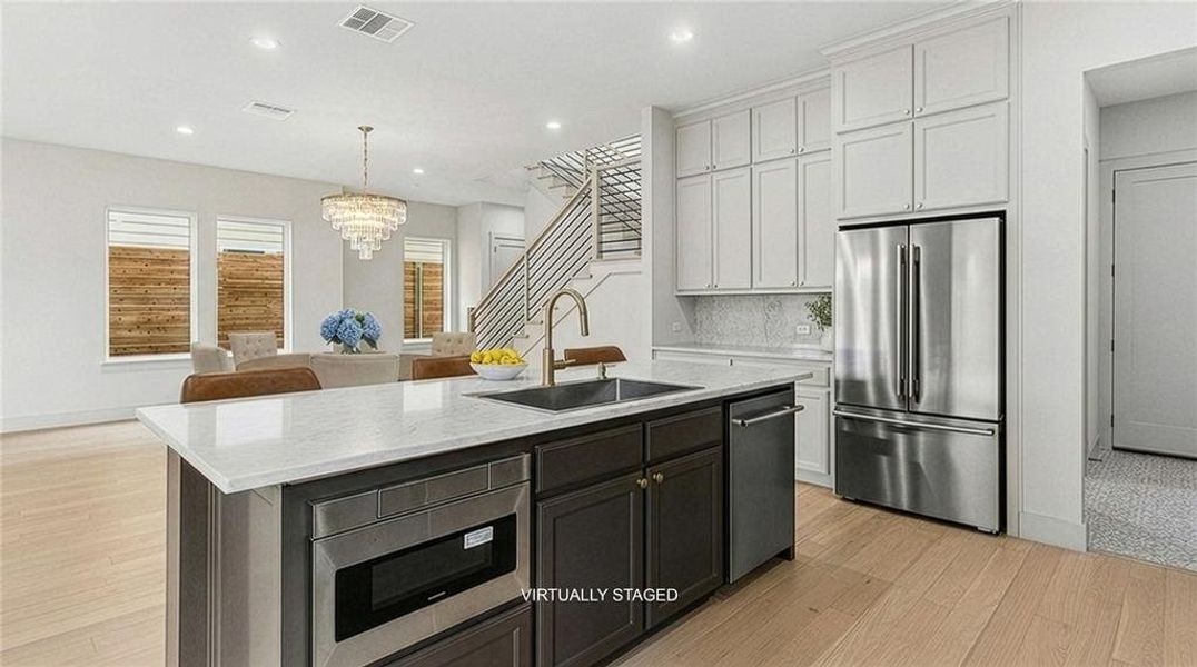Kitchen island with a light-toned countertop and an integrated stainless steel microwave Kitchen island with a light-toned countertop and an integrated stainless steel microwave