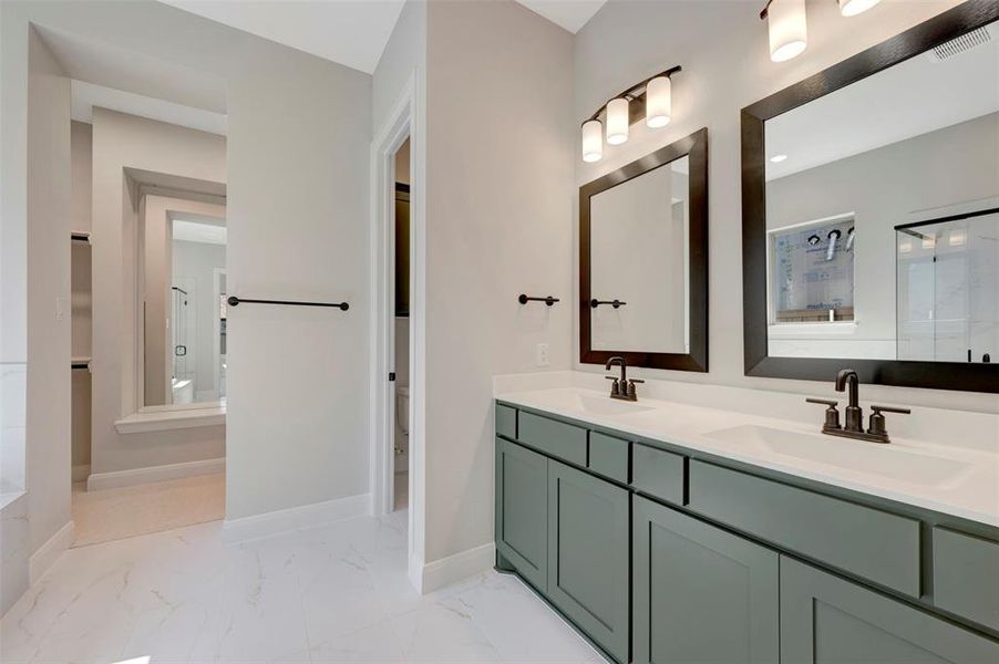 Full bath featuring double vanity and light marble finish flooring Full bath featuring double vanity and light marble finish flooring