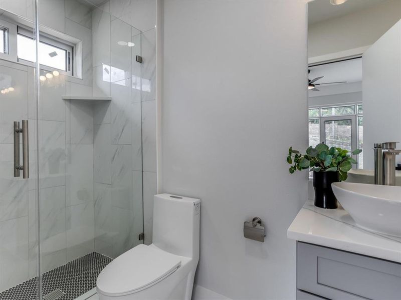 Modern bathroom featuring a walk-in shower with clear glass enclosure and a built-in shower niche Modern bathroom featuring a walk-in shower with clear glass enclosure and a built-in shower niche