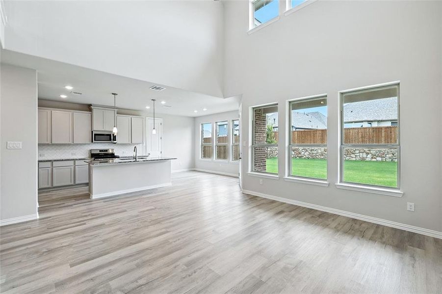 Unfurnished living room featuring light wood-style flooring and recessed lighting Unfurnished living room featuring light wood-style flooring and recessed lighting