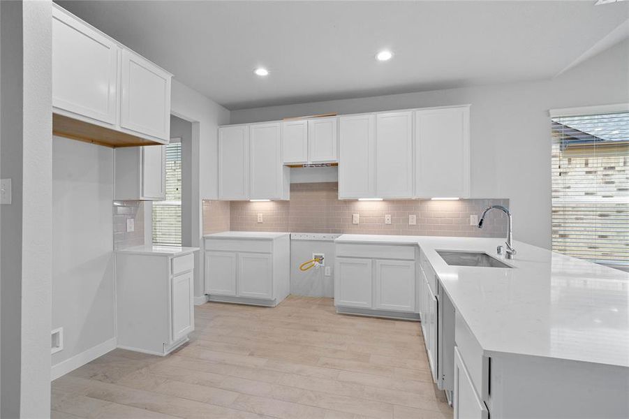 This kitchen is by far any chef’s dream! This spacious kitchen features high ceilings, white stained wood cabinets, quartz countertops, SS appliances, modern tile backsplash, recessed lighting, extended counter space for breakfast bar, and a walk-in pantry all overlooking your huge family room.