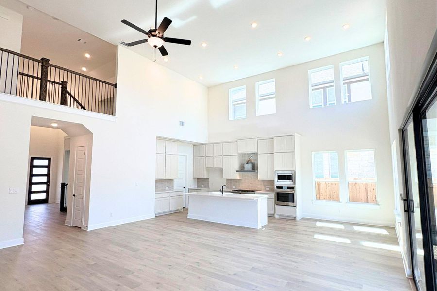 High ceilings and towering windows frame the expansive open kitchen and living area. High ceilings and towering windows frame the expansive open kitchen and living area.