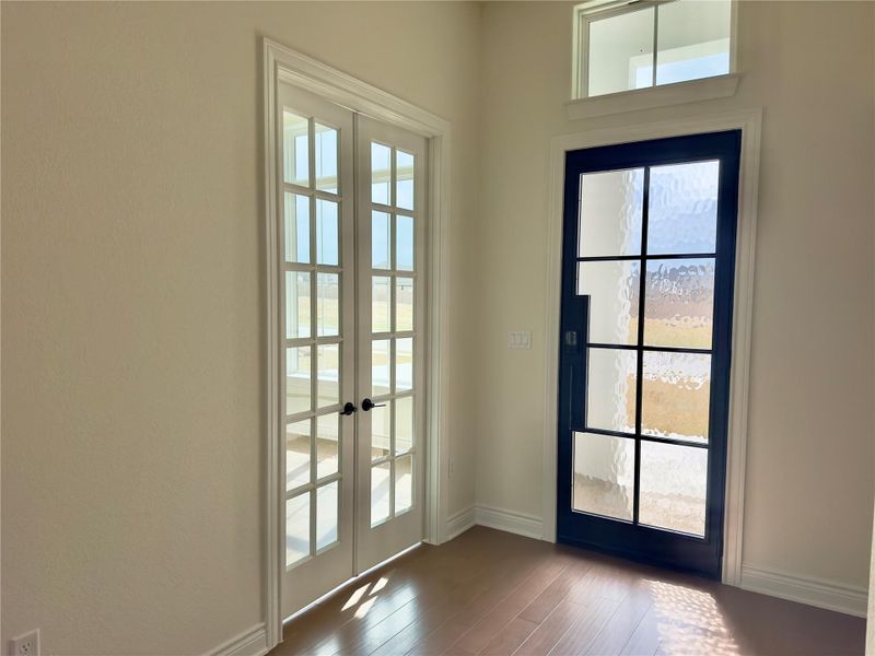 Doorway featuring french doors, plenty of natural light, and wood-type flooring