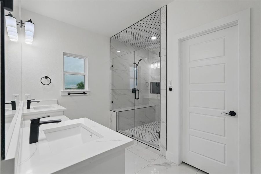 Full bathroom featuring marble look tiles, a marble finish shower, and double vanity Full bathroom featuring marble look tiles, a marble finish shower, and double vanity