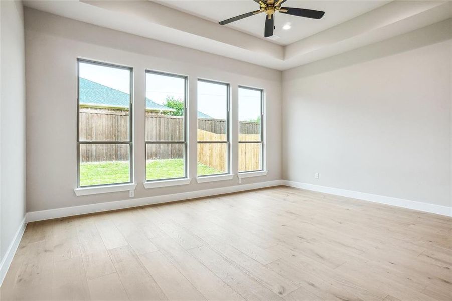 Primary bedroom has engineered wood flooring, boxed ceiling with fan and led can lights plus flat screen wiring. Primary bedroom has engineered wood flooring, boxed ceiling with fan and led can lights plus flat screen wiring.