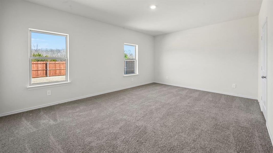 Spacious room featuring neutral carpet flooring and white walls