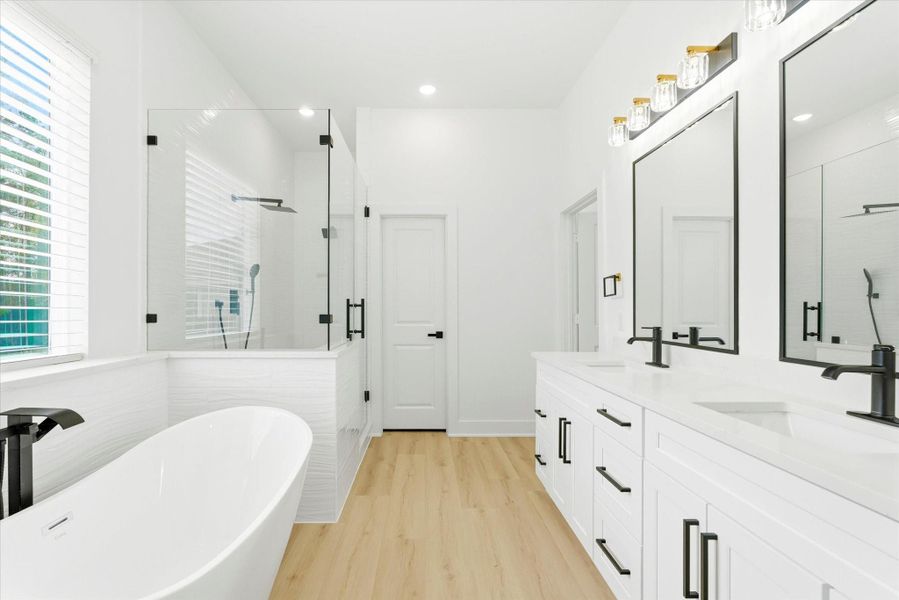 Dual vanities with ample storage and a private water closet complete this five-piece bathroom.