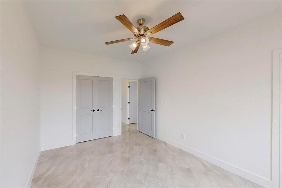 Unfurnished bedroom featuring a ceiling fan and a closet