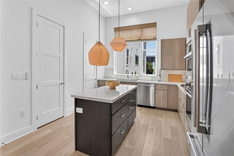 Culinary aspirations come alive in this well-appointed kitchen featuring light hardwood flooring and recessed lighting.