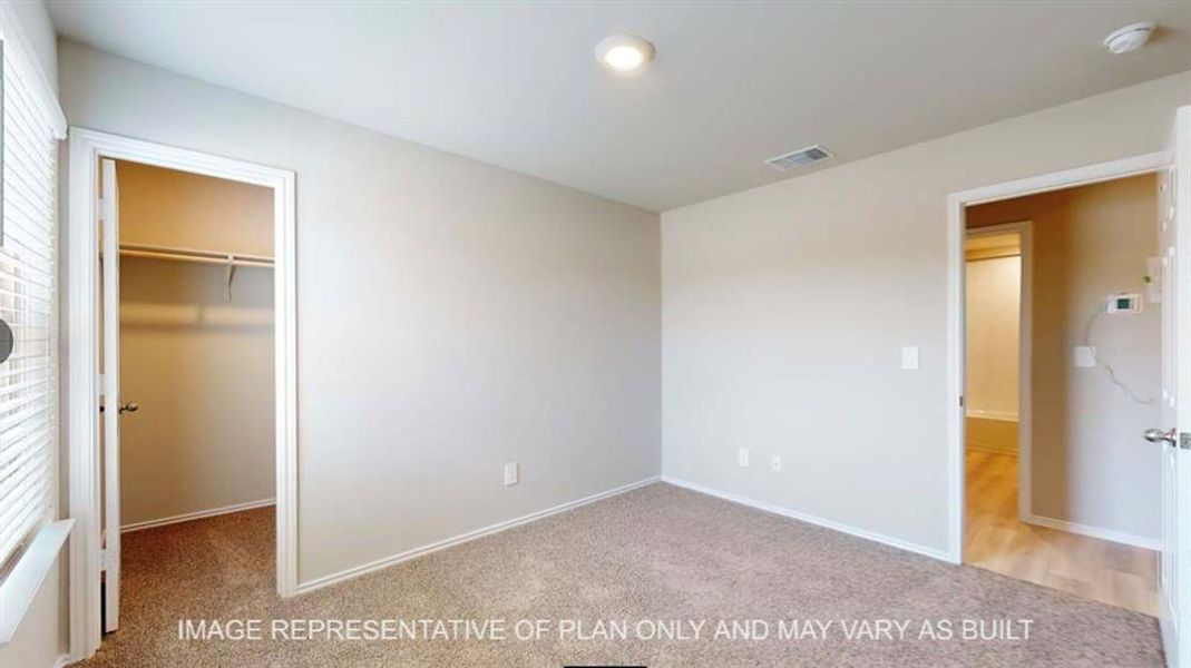 Unfurnished bedroom featuring a spacious closet and light colored carpet