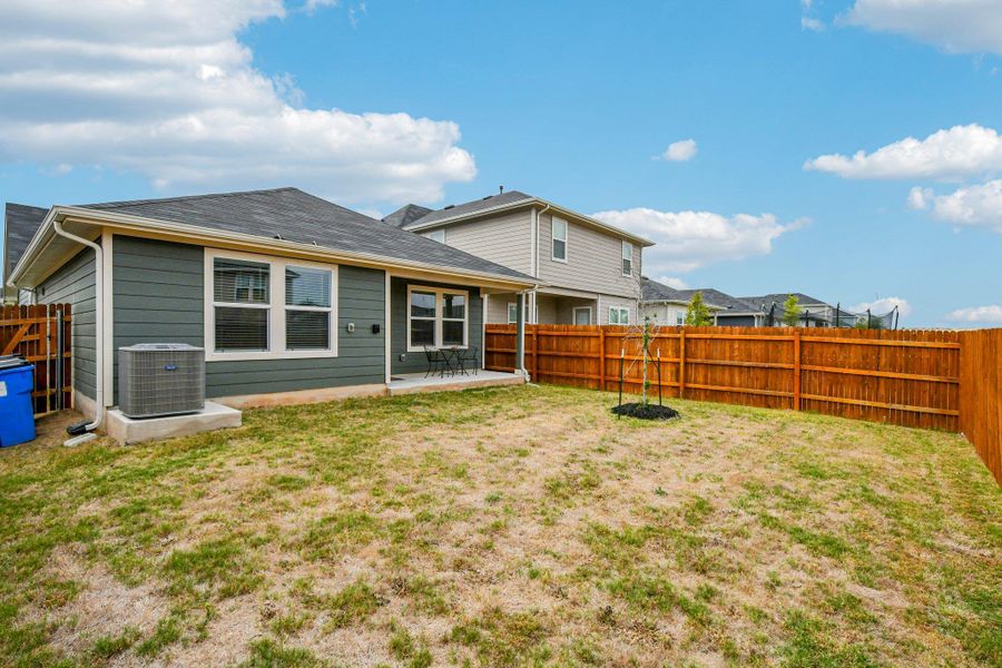 Rear view of property with a fenced backyard and a patio