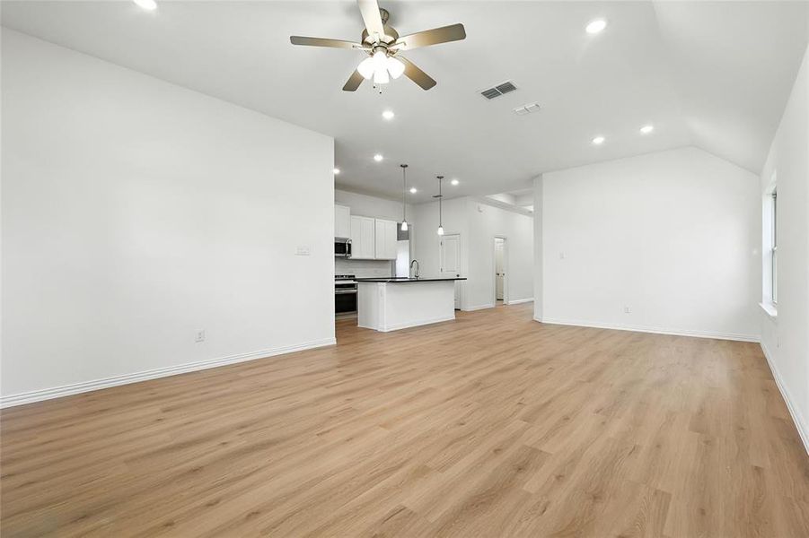 Unfurnished living room with recessed lighting, ceiling fan, light wood-type flooring, and lofted ceiling