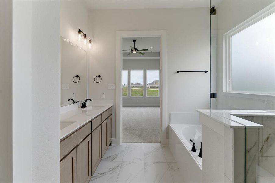 Spacious bathroom featuring a double vanity with stone countertops, undermount sinks, and matte black fixtures
