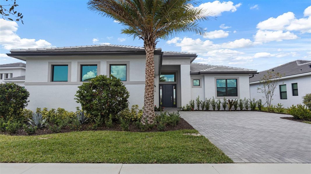 Front exterior of a new home in Cresswind Palm Beach at Westlake, Westlake, FL, highlighting curb appeal (Image 2). Front exterior of a new home in Cresswind Palm Beach at Westlake, Westlake, FL, highlighting curb appeal (Image 2).