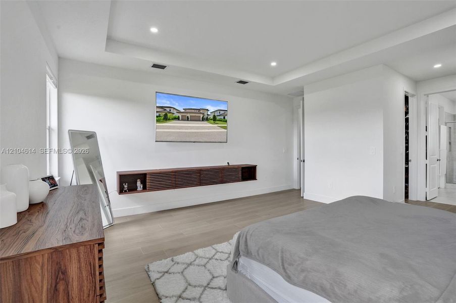 Recessed lighting, tray ceiling, light wood look flooring
