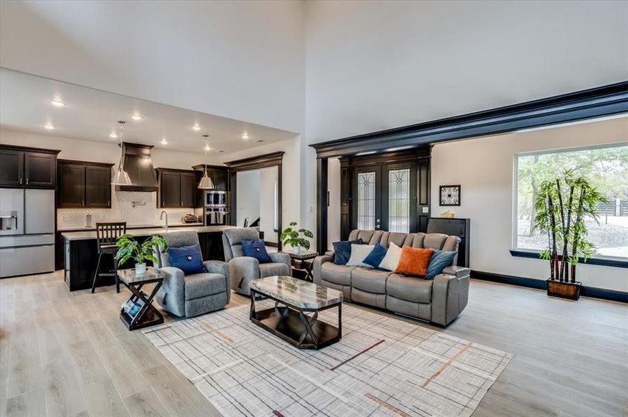 Living area with recessed lighting, light tile flooring, and a high ceiling