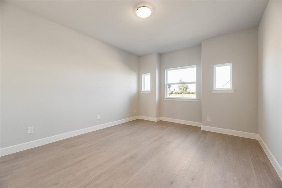 Spare room with light wood-type flooring and baseboards Spare room with light wood-type flooring and baseboards