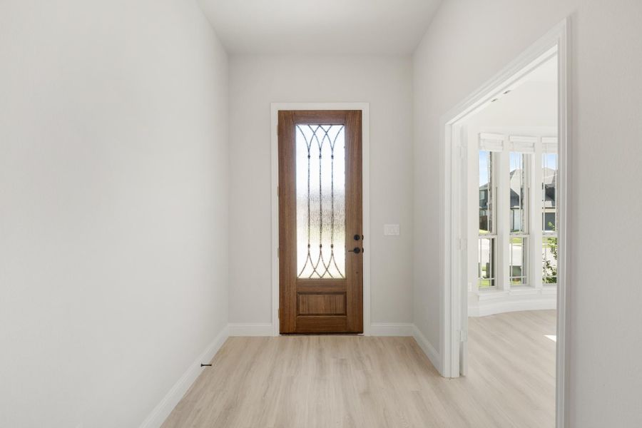 Entryway with wood front door featuring decorative glass panel and light hardwood floors