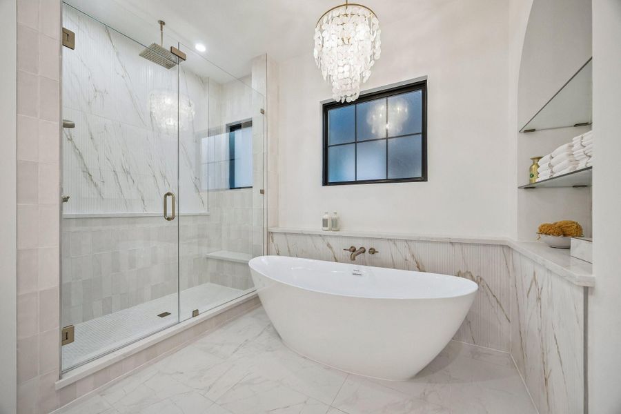 Large Walk-in Shower with a Framless Shower Enclosure.  The Floor in the shower is adorned with White Matt Penny Round 2 x 2 Mosaic Tile.  The Shower walls are a mixture 3 x 9 Glazed Tile and 16 x 48 Ribbed Urbanslat Marmi Gold Tile.