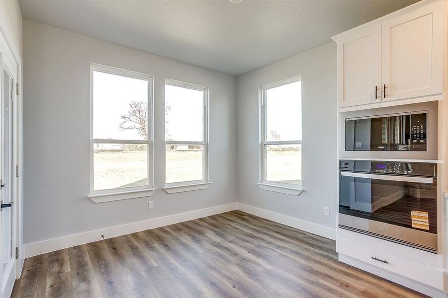 Kitchen featuring appliances with stainless steel finishes, white cabinetry, and light wood finished floors