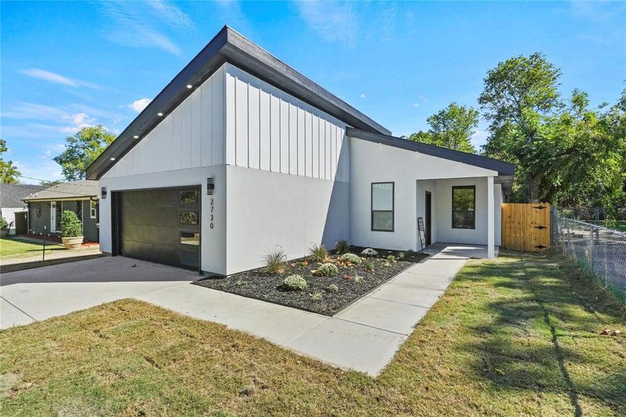 View of front facade with a garage and a front lawn