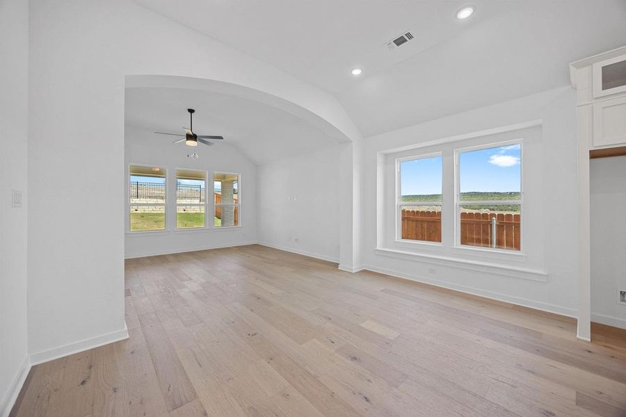 Unfurnished living room featuring vaulted ceiling, a ceiling fan, light wood-style flooring, and recessed lighting