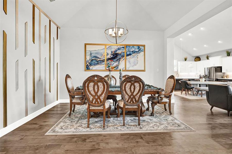 Dining area featuring vaulted ceiling, recessed lighting, light wood-style flooring, and a chandelier