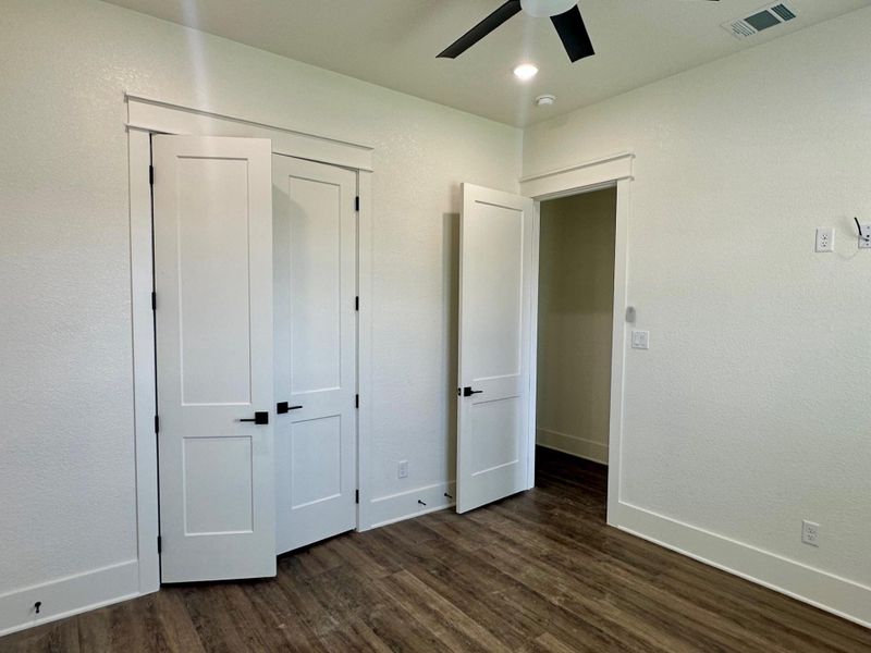 Unfurnished bedroom featuring dark wood-style flooring, a ceiling fan, a closet, and recessed lighting