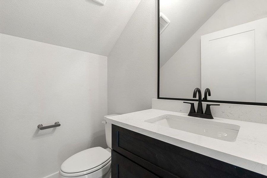 Bathroom with vanity and lofted ceiling