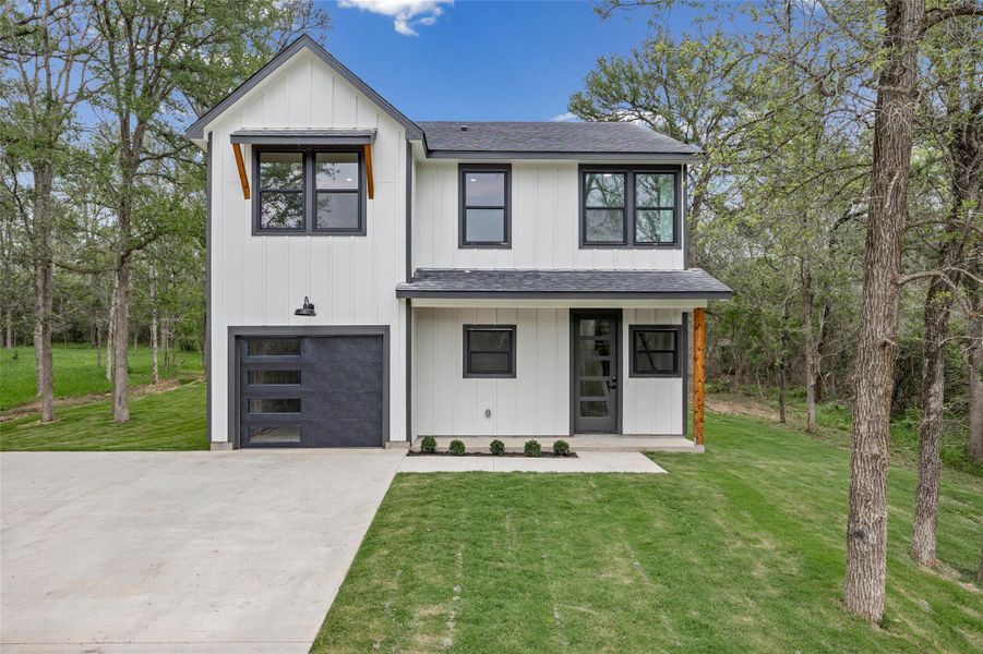 Modern farmhouse with extended driveway surrounded by towering pine trees Modern farmhouse with extended driveway surrounded by towering pine trees