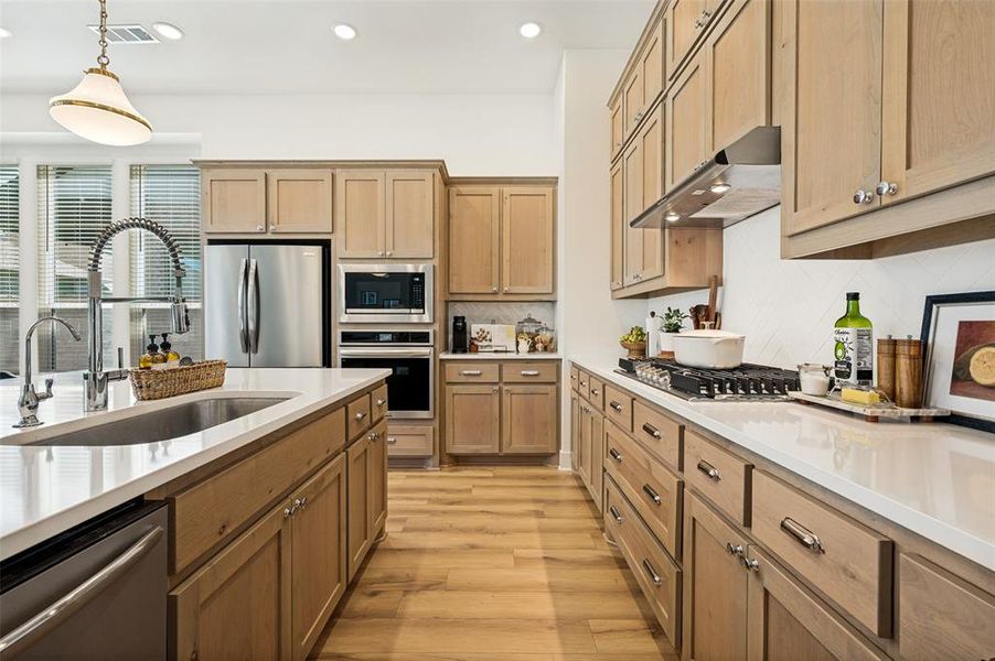 Large white countertops, farmhouse sink and stainless appliances
