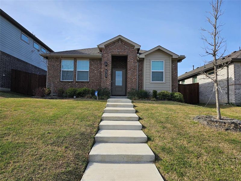 Ranch-style home featuring a front yard and brick siding
