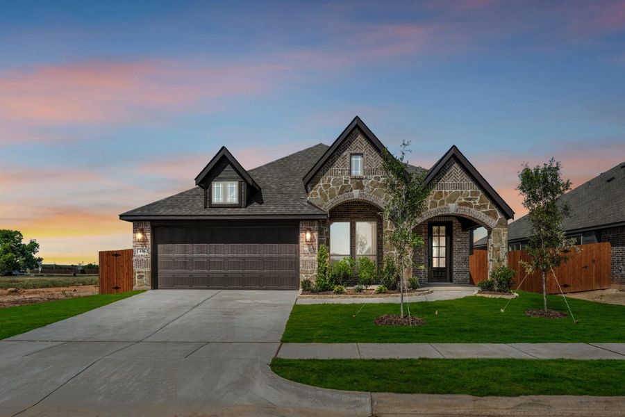 Single-story home with stone and brick exterior, two-car garage, arched entry, and manicured front lawn at dusk Single-story home with stone and brick exterior, two-car garage, arched entry, and manicured front lawn at dusk