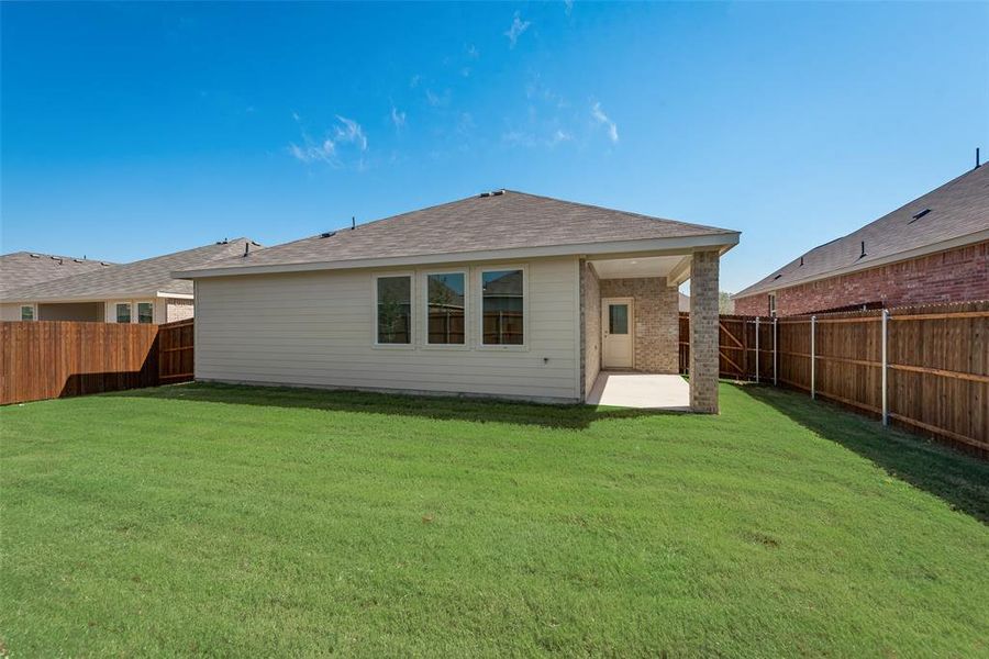 Rear view of property with a lawn