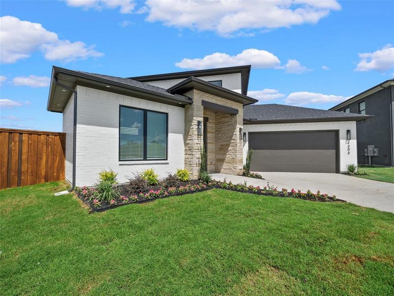 View of front of home with a garage and a front lawn