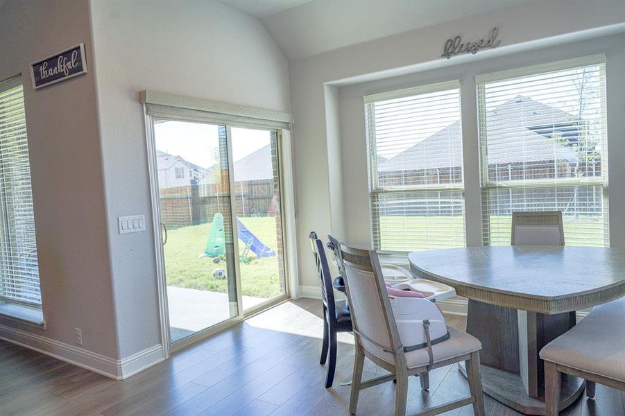 Dining room with wood finished floors and lofted ceiling