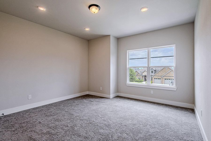 Comfortable bedroom featuring large windows and neutral finishes Comfortable bedroom featuring large windows and neutral finishes