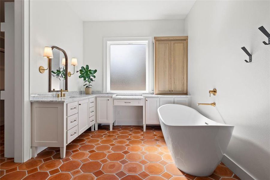 Full bathroom featuring vanity, a freestanding tub, and light tile patterned flooring
