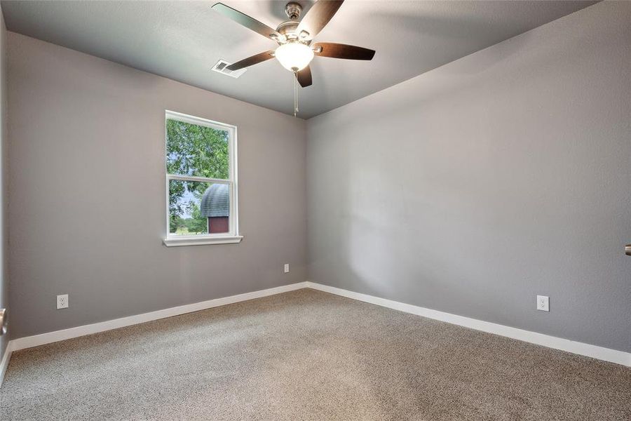 Carpeted empty room featuring ceiling fan