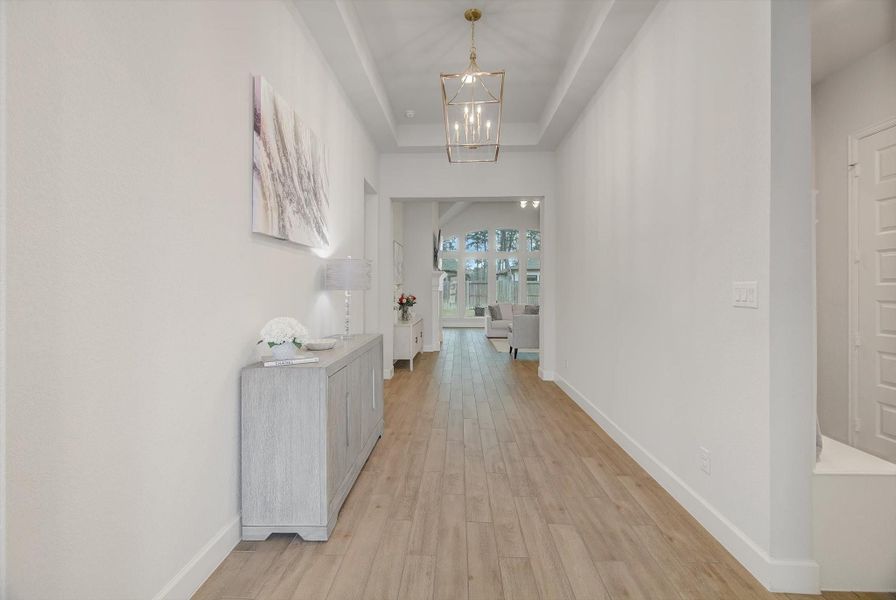 Open the front door to a bright, welcoming foyer with soaring 12' ceilings and stylish light fixtures that instantly elevate the space.